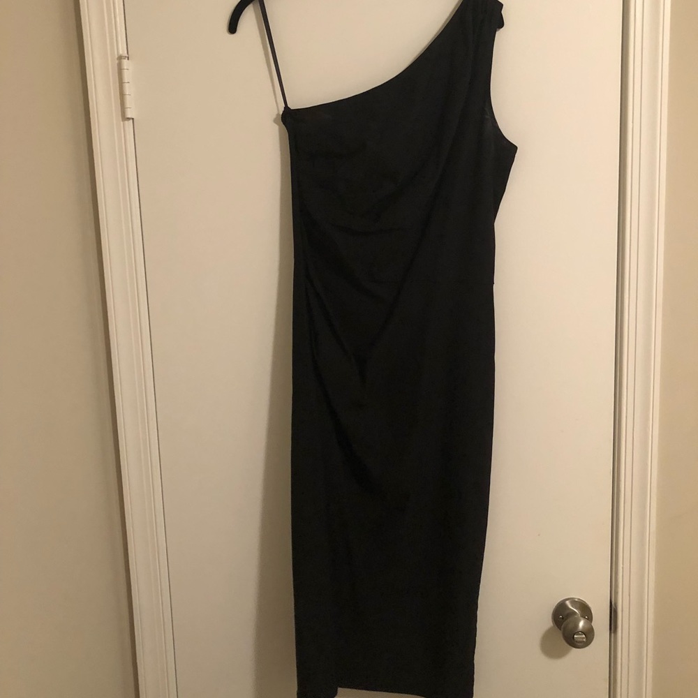 Sleeveless/one-strap form fitting black dress.